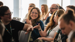 Woman laughing surrounded by a crowd of people